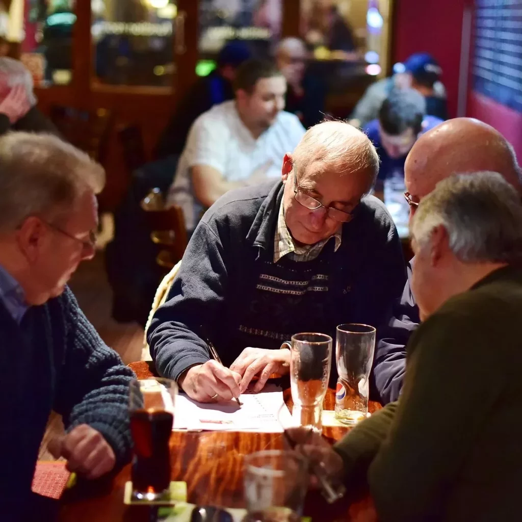 Men in a pub doing a quiz